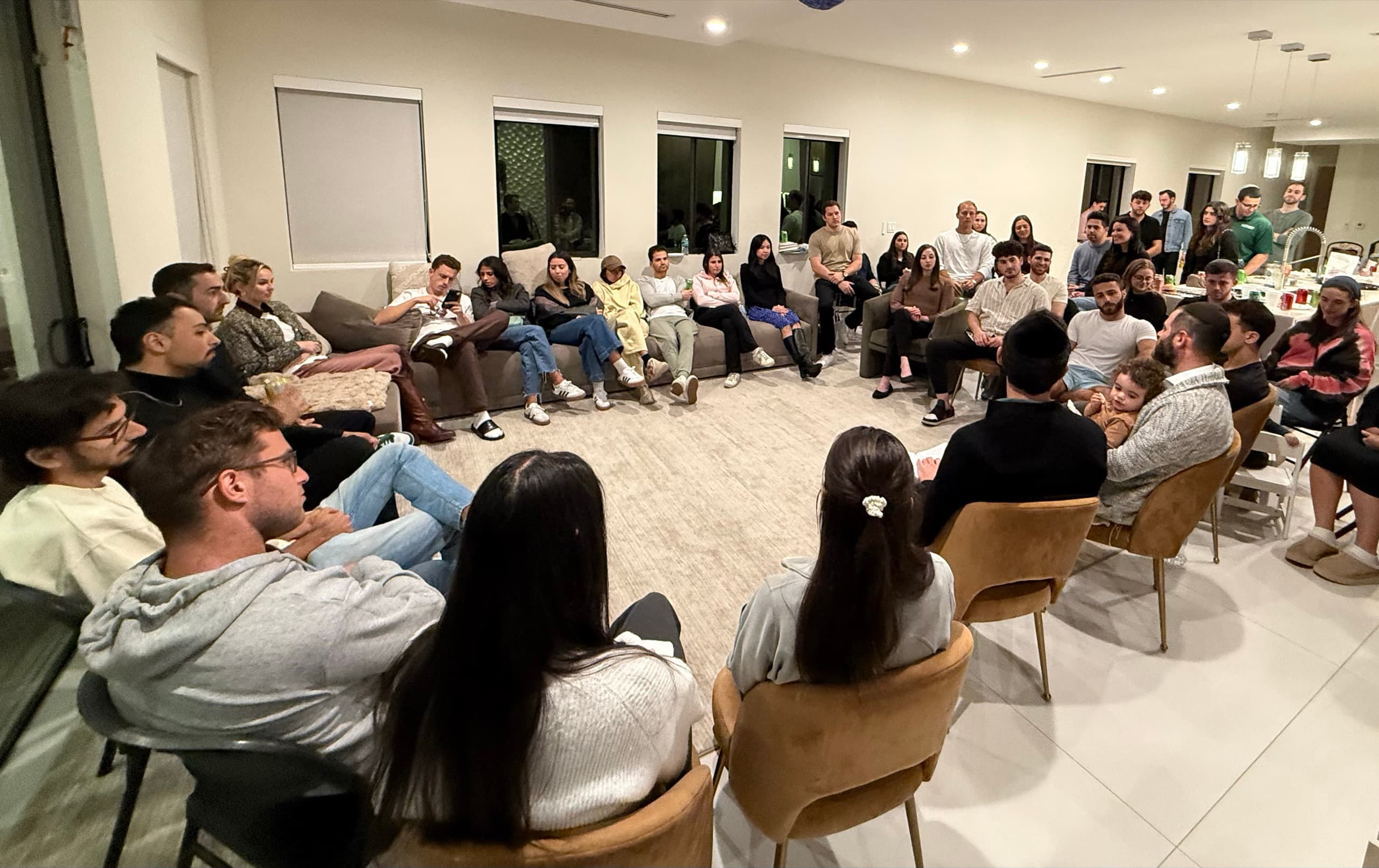 A packed Torah class, everyone in a circle